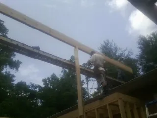 Carpenter setting a ridge beam over a new addition frame — Ice Dam Removal by Roofing Brothers in Maiden