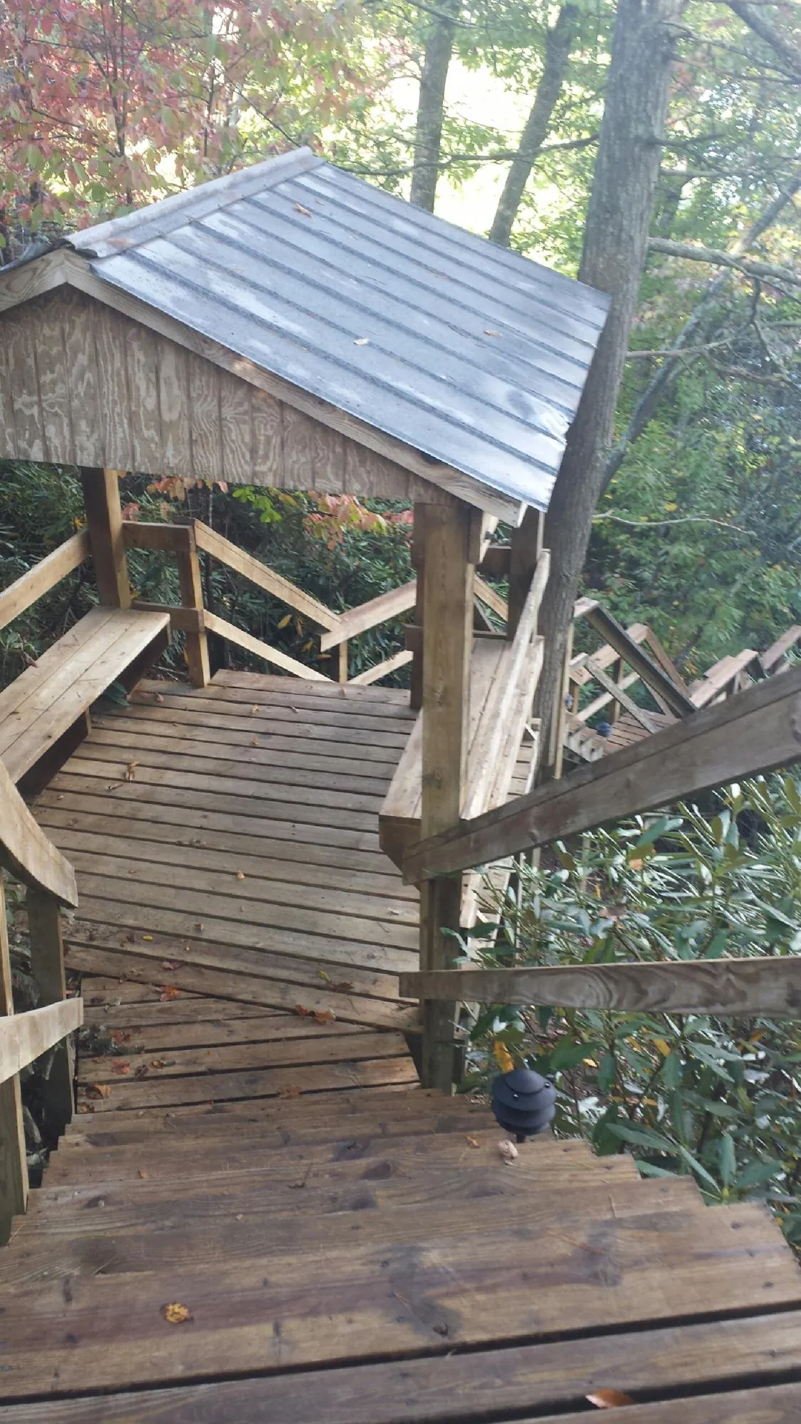 Metal roofed shelter over wooden steps on a wooded walkway — Skylight Repair & Installation work by our crew in Maiden