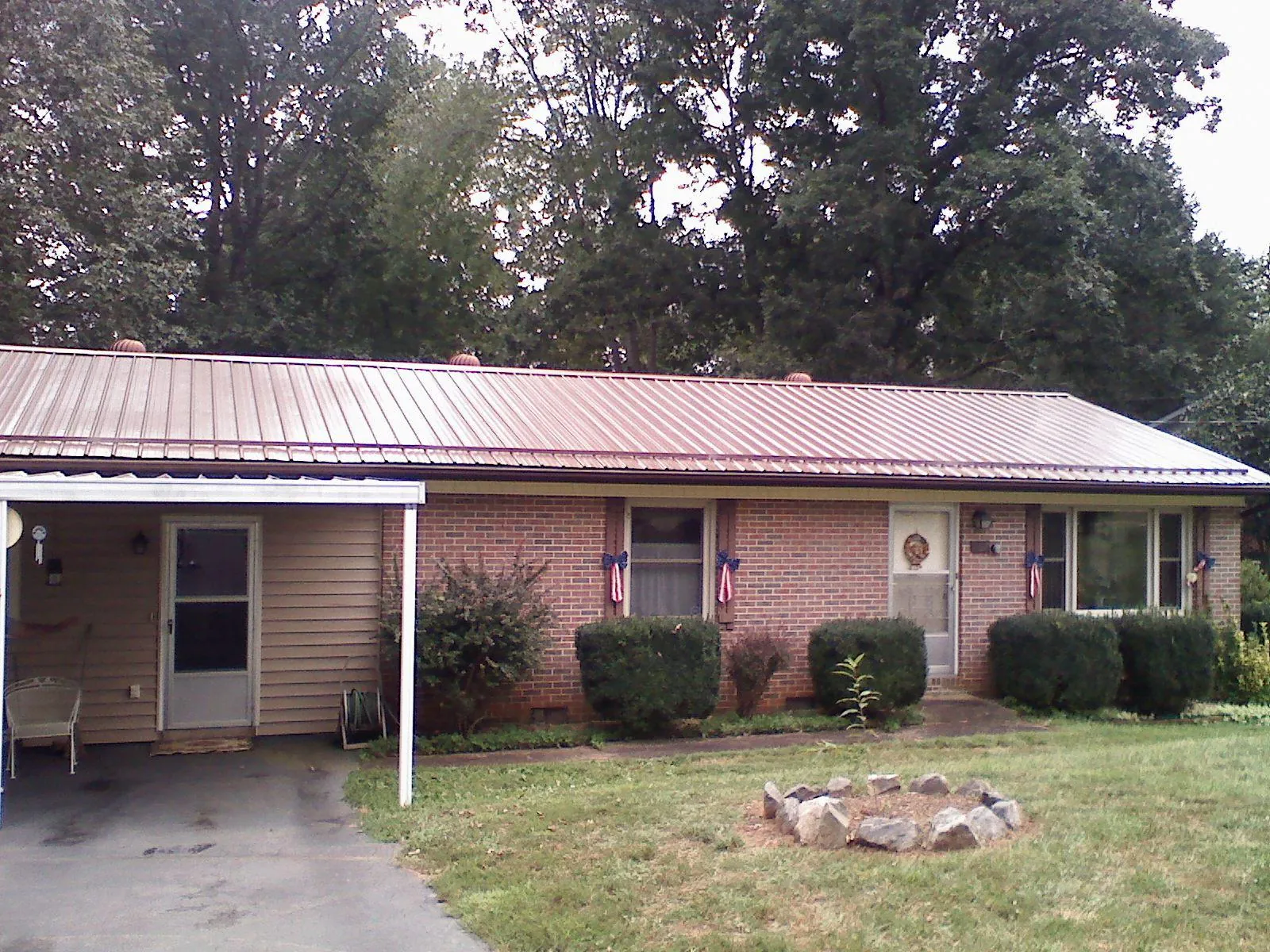 Bronze metal roof and carport on a brick ranch home — Roof Repair work by our crew in Maiden