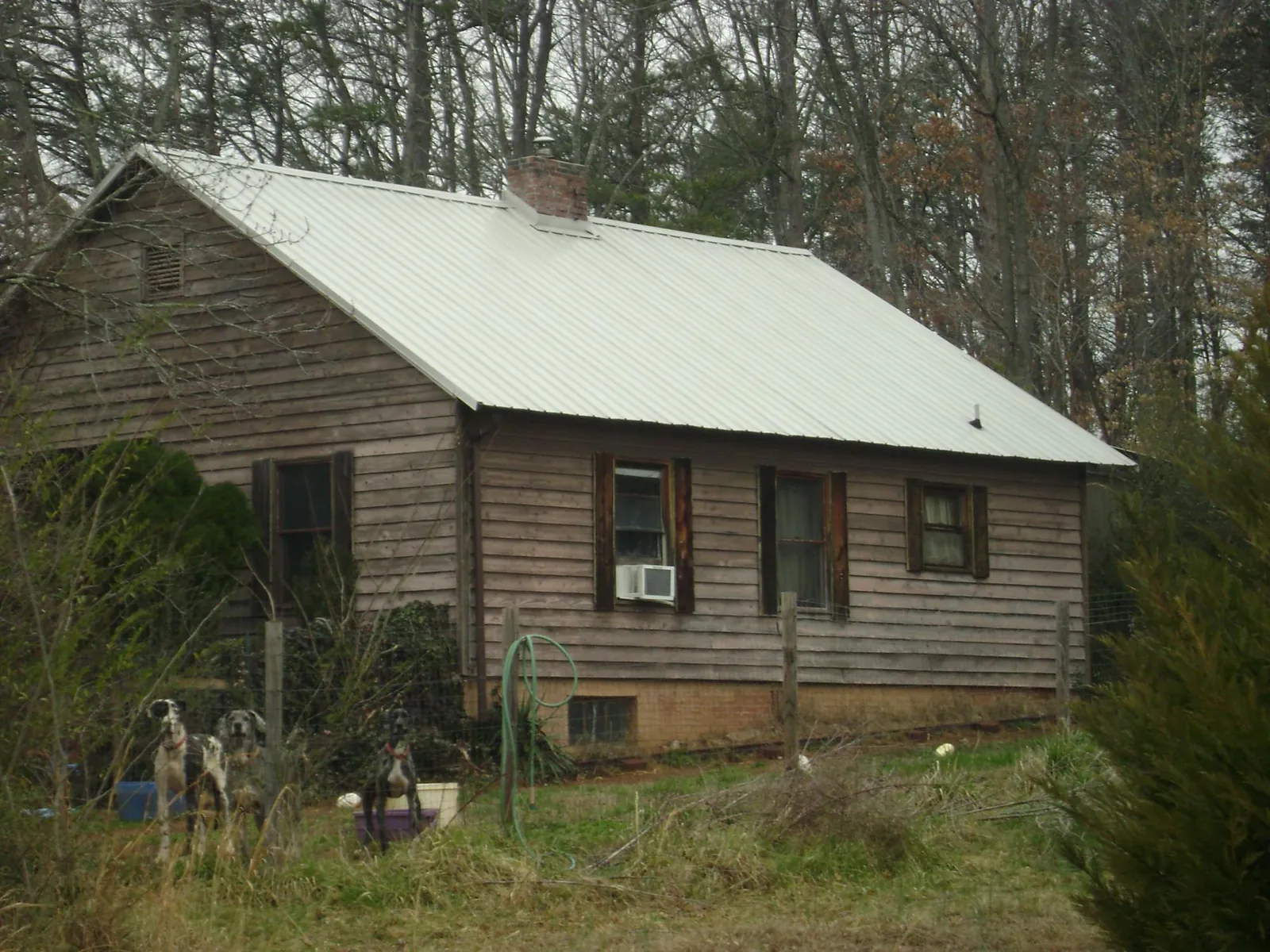 White metal roof on an old wood sided farmhouse, from a Metal Roof Installation job in Maiden